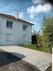 a white house with a playground in the yard at Comfortable studio dans une maison au calme in Bellerive-sur-Allier