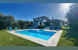 a house with a swimming pool in the yard at V Mira Luxury Villa in Tragaki