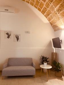 a living room with a couch and a tv at Corte San Giorgio in Matino