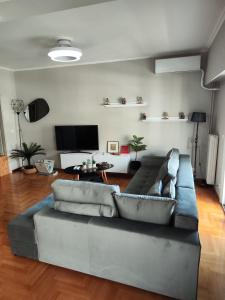 a living room with a couch and a flat screen tv at 110 Sqm 2BR Edem beach luxury apartment in Athens