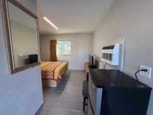 a small hotel room with a bed and a bathroom at Bel-Air Motel in Alice