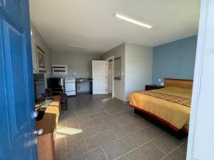a hotel room with a bed and a kitchen and a room at Bel-Air Motel in Alice