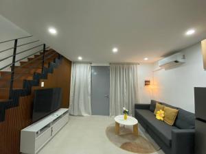 a living room with a couch and a tv at Cozy Haven Batulao in Calo