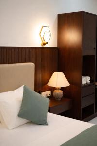 a bedroom with a bed with a lamp on a table at Yaazoraa Anuradhapura in Maha Kalattewa