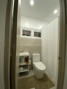 a small bathroom with a toilet and a sink at Cozy Haven Batulao in Calo