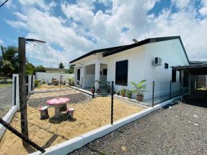 a white house with a fence in front of it at Homestay Teratak Nailufar in Pekan