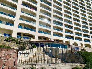 a large building with a fence in front of it at Mar y Sol 16th floor Condo in Rosarito +24 photos