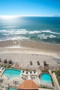 an aerial view of a beach with two swimming pools at Mar y Sol 16th floor Condo in Rosarito