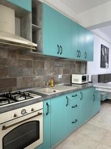 a kitchen with blue cabinets and a stove top oven at Travel Studio in Iaşi