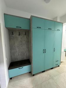 a large blue cabinet with a bench in a room at Travel Studio in Iaşi
