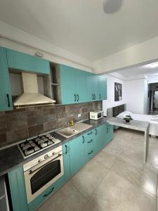 a kitchen with blue cabinets and a stove top oven at Travel Studio in Iaşi