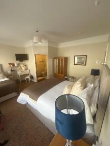 a bedroom with a large bed and a desk at Ashmore House Cashel in Cashel