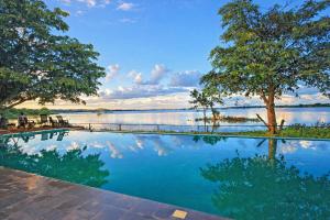 a swimming pool with a view of a lake at Yaazoraa Anuradhapura in Maha Kalattewa