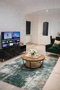 a living room with a coffee table and a tv at Spacious 2 bedoom house in Wyken