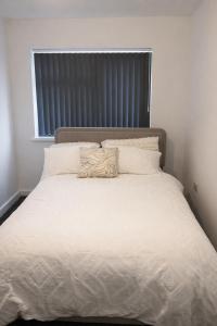 a white bed with a pillow on top of it at Spacious 2 bedoom house in Wyken