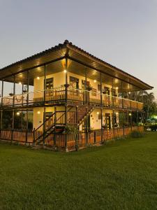 a large house with a large deck and a yard at Finca Hotel el Palmar in Montenegro