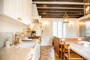 a kitchen with white cabinets and a wooden ceiling at Manoir La Ville Durand in Binic