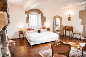 a bedroom with a white bed and two chairs at Manoir La Ville Durand in Binic