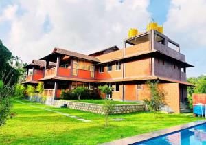 a house with a swimming pool in front of it at Pepper Corn Retreat By Travent Mug in Sakleshpur +55 photos