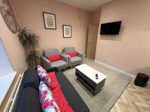 a living room with a couch and a tv at Bright Harrogate flat 2 beds great location in Harrogate