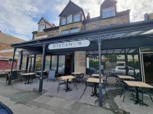 a restaurant with tables and chairs in front of a building at Bright Harrogate flat 2 beds great location in Harrogate