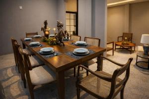 a dining room with a wooden table and chairs at Yaazoraa Anuradhapura in Maha Kalattewa