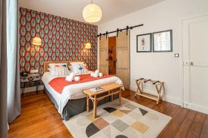 a bedroom with a bed and a table in it at La Demeure N 5 in Cambrai
