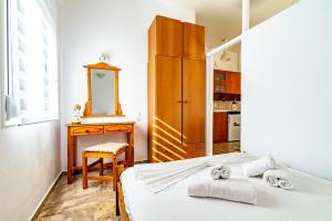 a bedroom with a bed and a dresser and a mirror at Irene Studio in Amoudara Herakliou