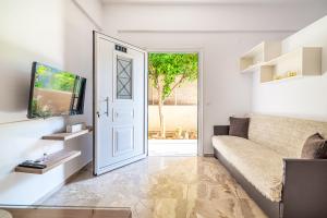 a living room with a couch and a door at Irene Studio in Amoudara Herakliou