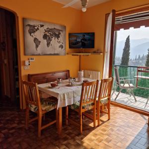 a dining room with a table and chairs and a balcony at LA PERLA DEL CENTRO LAGO DI COMO in Perledo