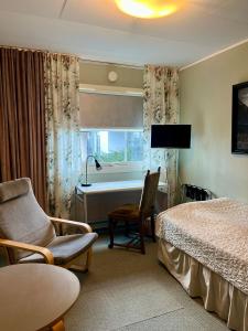 a hotel room with a bed and a chair and a window at B&B Ströprodukter in Eslöv