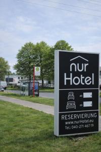 a sign for a hotel on the grass next to a road at nurHotel in Reinbek