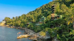 a resort on a hill next to a body of water at Villa Lala Boutique Hotel Adults Only in Puerto Vallarta