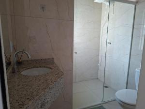 a bathroom with a shower and a sink and a toilet at Hotel Pampa in Nova Santa Medianeira