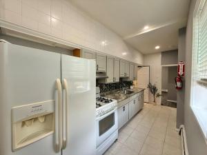 a kitchen with white appliances and white cabinets at Modern apartment close to NYC in North Bergen +21 photos