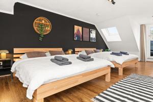 two beds in a bedroom with black walls and wooden floors at Tucan - Rooftop Terrace with View, BBQ, PS4+Stream in Marburg an der Lahn