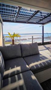 a couch in a living room with a view of the beach at Penthouse Seebrise in Großräschen