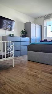 a bedroom with a bed and blue cabinets and a kitchen at Penthouse Seebrise in Großräschen +36 photos