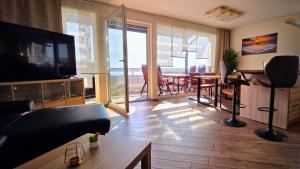 a living room with a couch and a television and a table at Penthouse Seebrise in Großräschen