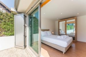 a bedroom with a bed and sliding glass doors at GuestReady - Charming beachside retreat in Mindelo +20 photos