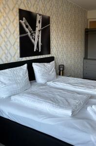a large white bed with a clock on the wall at Günstige Ferienwohnung 2 Pers zentral Hamburg BoLA 48 in Hamburg +12 photos