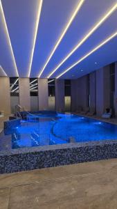 a large swimming pool in a building with blue lights at 4 Sosny Porta Mare in Dziwnówek