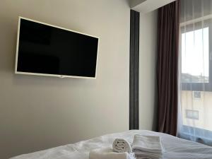 a bedroom with a flat screen tv on the wall at Solivara Aparthotel 7 SELF CHECK-IN #Otopeni #Airport #Therme #Bucharest in Otopeni