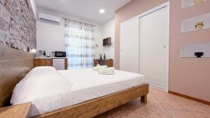 a bedroom with a large bed and a stone wall at Hortensia House in Cefalù