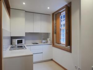 een keuken met witte kasten en een raam bij Belomont6 Apartments in Porto +43 foto's