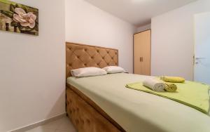 a bedroom with a large bed with two pillows on it at Olive View apartment in Rafailovici