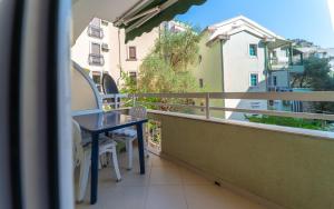 a balcony with a table and a view of a building at Olive View apartment in Rafailovici