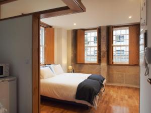 een slaapkamer met een bed en twee ramen bij Belomont6 Apartments in Porto
