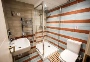 a bathroom with a shower and a toilet and a sink at Revolver Glasgow in Glasgow