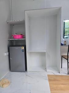 a kitchen with a refrigerator in the middle of a room at Avatar Resort Phangan Thailand in Ban Nua
